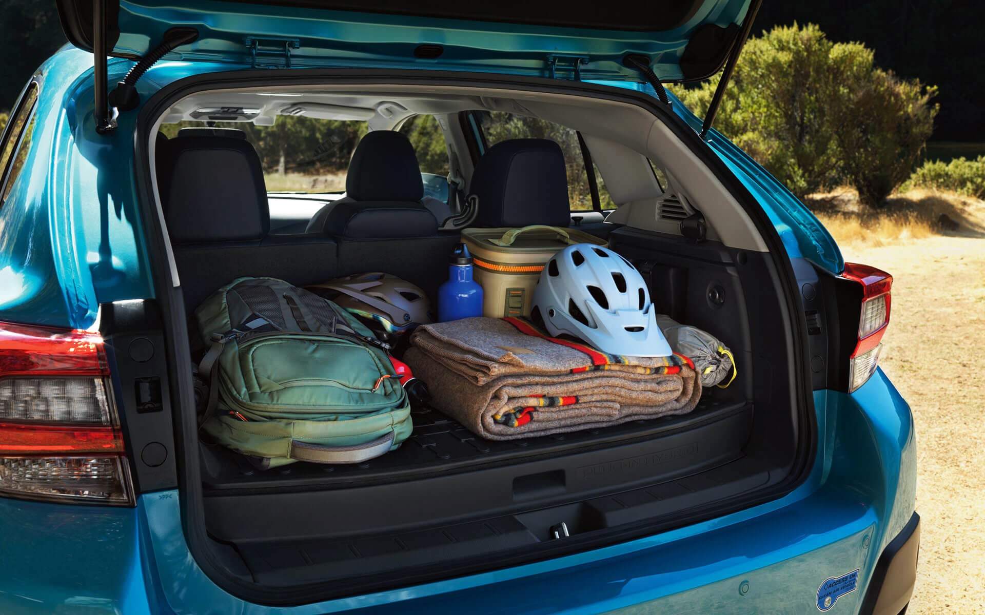 A backpack, blanket, and bike helmet in the rear cargo area of a Crosstrek Hybrid | Thelen Subaru in Bay City MI