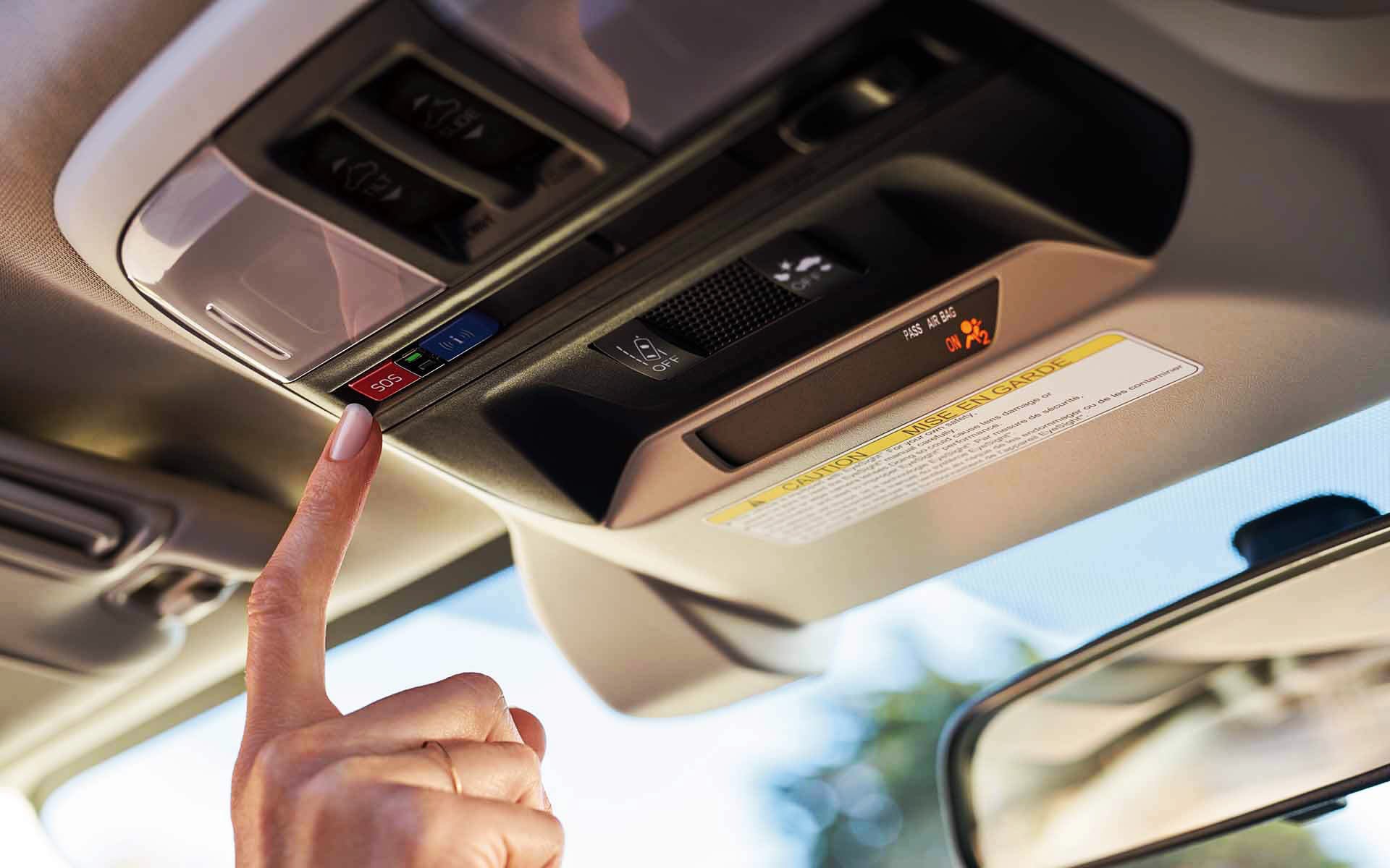 A finger pressing the Crosstrek Hybrid's SOS emergency assistance button | Thelen Subaru in Bay City MI