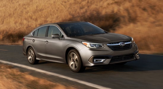 The 2022 Subaru Legacy driving on a road.