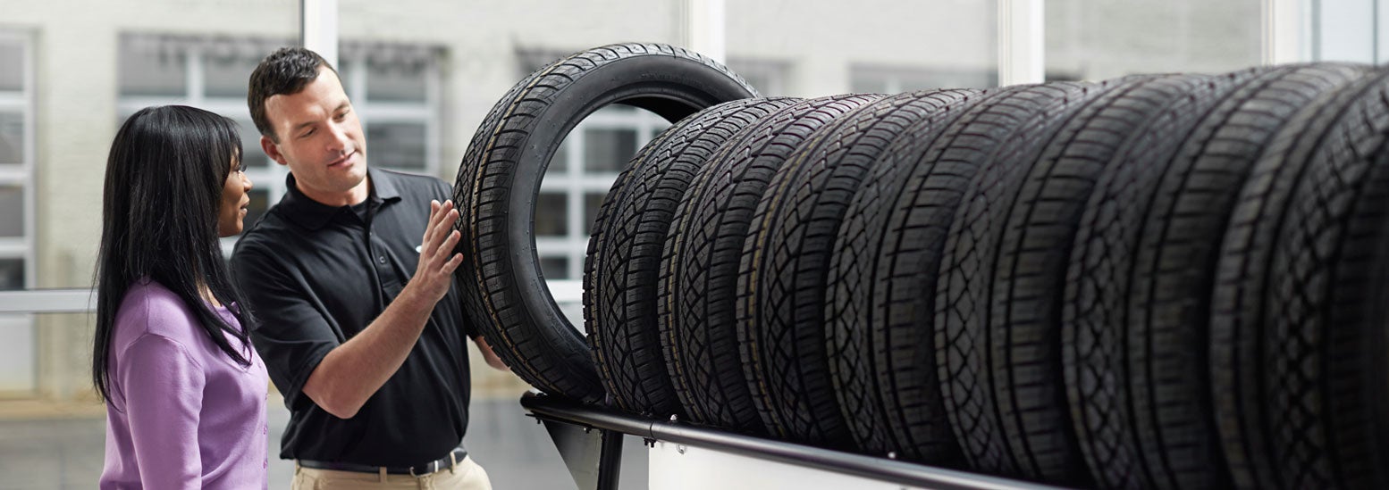 Subaru service representative showing customer a tire. | Thelen Subaru in Bay City MI
