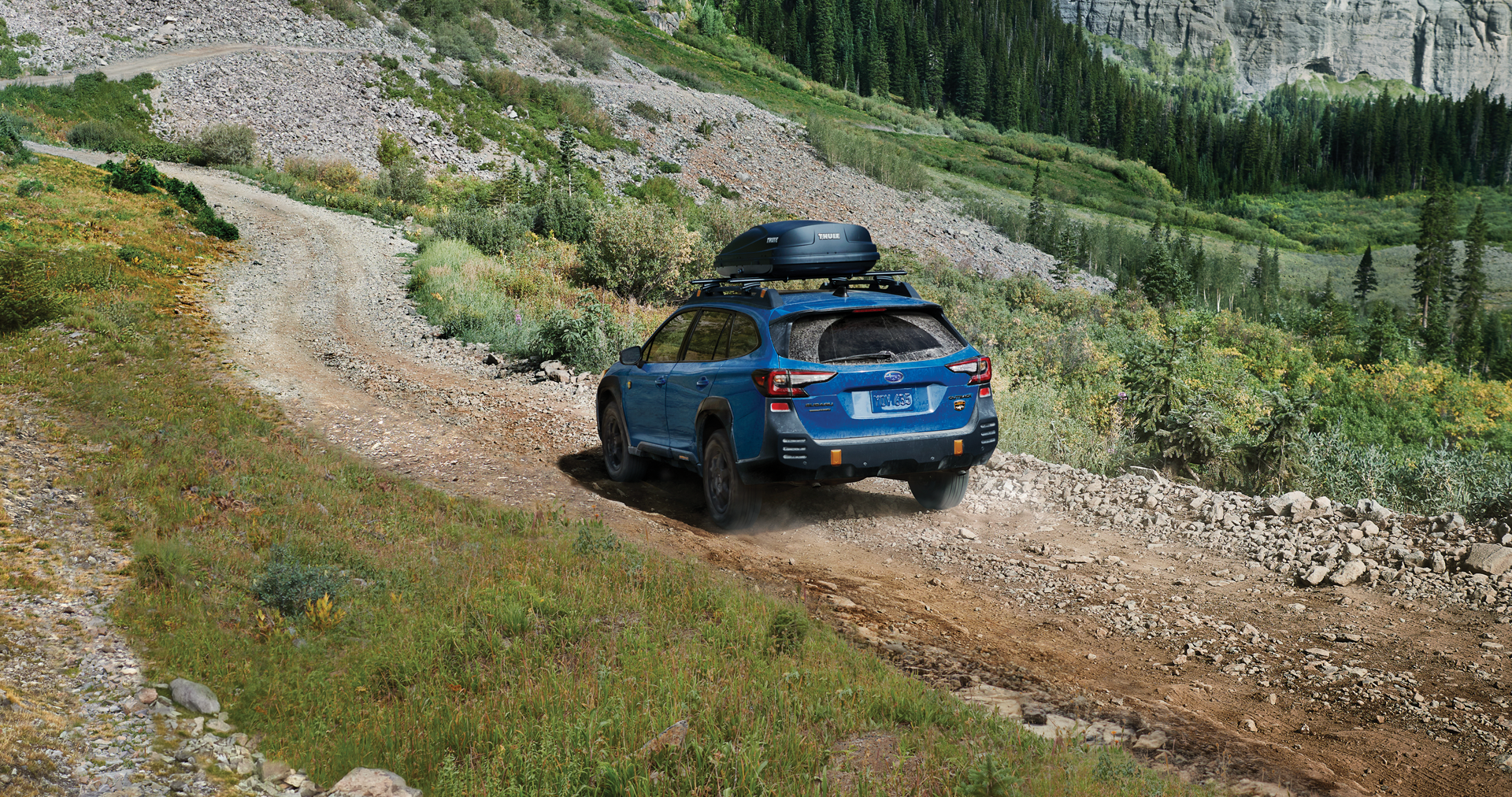 A 2023 Outback Wilderness driving on a trail in the mountains. | Thelen Subaru in Bay City MI